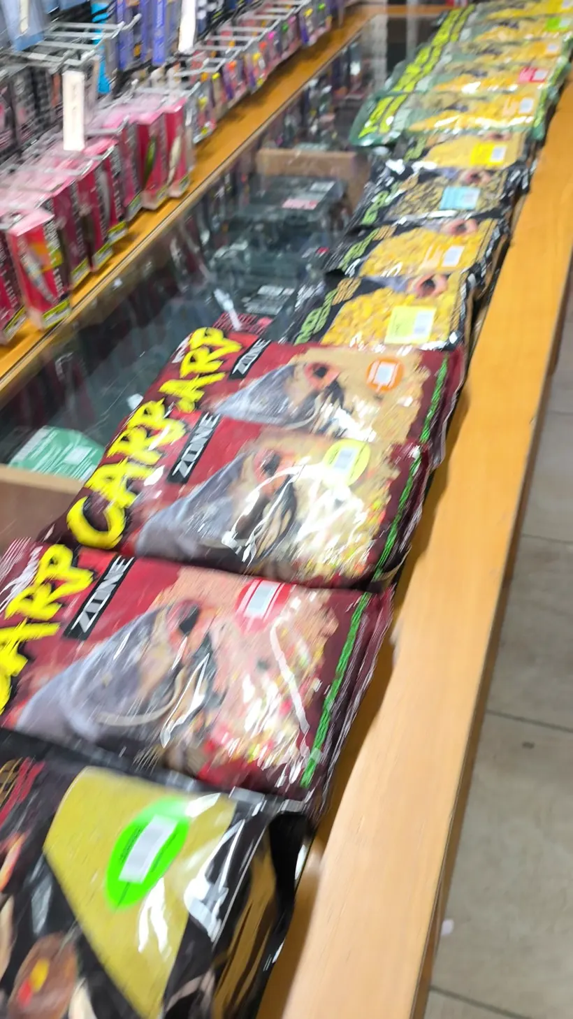 Bags of carp groundbait along a counter