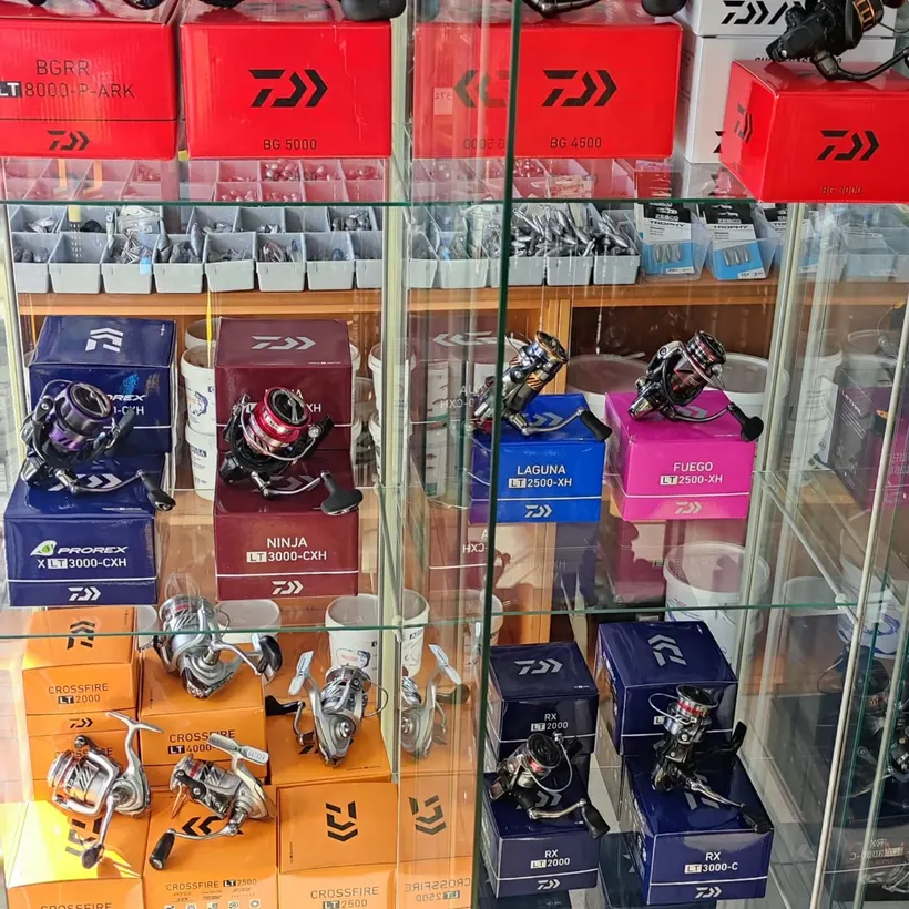 Glass case of Daiwa spinning reels in their boxes
